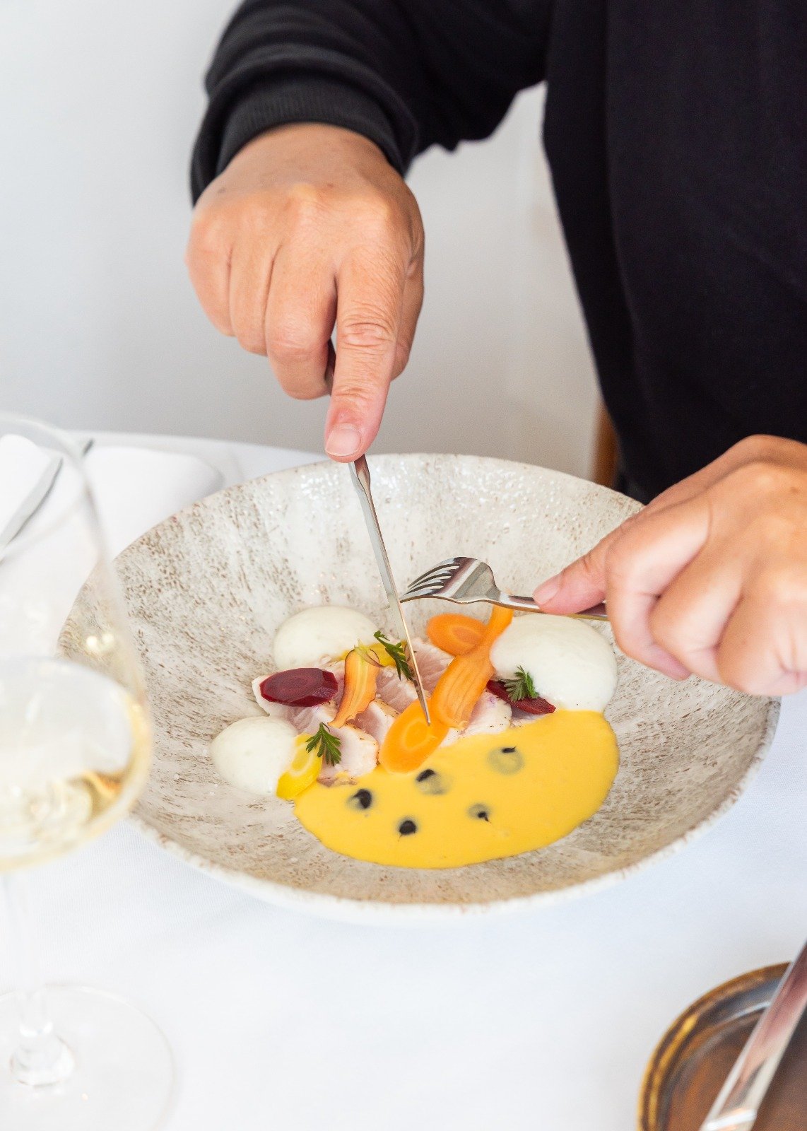 Hand cutting food on a plate