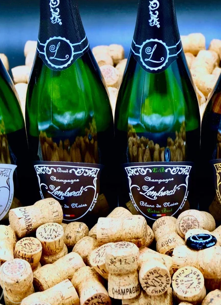 Champagne Lombardi bottles resting on a bed of natural corks